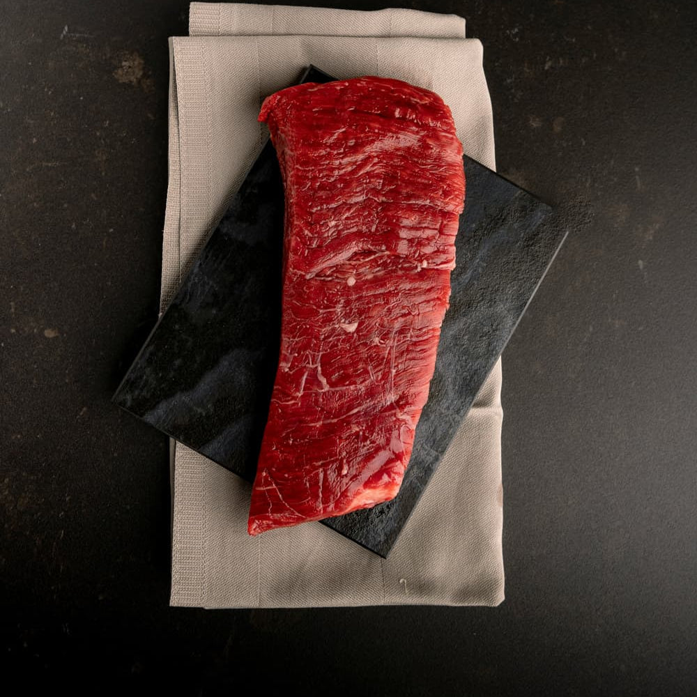 Rotes Stück Fleisch auf einem Tuch serviert