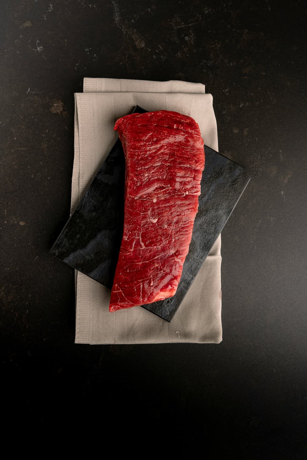 Rotes Stück Fleisch auf einem Tuch serviert